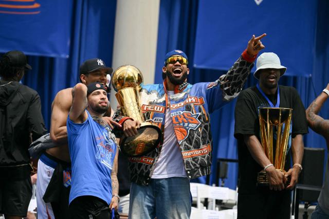 Karl-Anthony Towns (3R) #32 and Jose Alvarado (2L) #5 of the New York Knicks holds the Larry O'Brien Championship Trophy during a championship celebration and Key to the City ceremony at City Hall Plaza after a ticker-tape parade honoring the team's NBA Finals victory in New York City on June 18, 2026. (Photo by ANGELA WEISS / AFP)