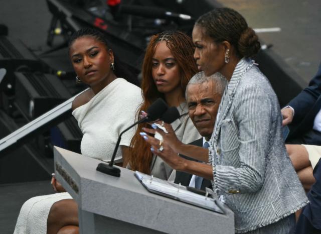 (L/R) Sasha Obama, Malia Obama and former US president Barack Obama listen to former US first lady Michelle Obama speak at the opening of the Barack Obama Presidential Center in Chicago, Illinois, on June 18, 2026. (Photo by Pedro UGARTE / AFP)