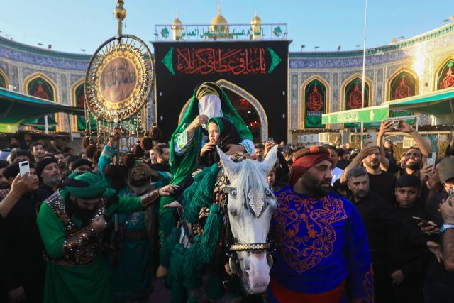 Shiite mourners take part in the Al-Haidariyah Public Procession reenacting the arrival of Imam Hussein, his family and companions in the Iraqi holy city of Karbala on the second day of Muharram, during commemorations marking Ashura on June 18, 2026. Ashura is one of the most important commemorations for Shiite Muslims, and falls on the 10th day of Muharram, which is the mourning period for the seventh-century killing of Imam Hussein, the grandson of the Prophet Muhammad. (Photo by Karar Jabbar / AFP)