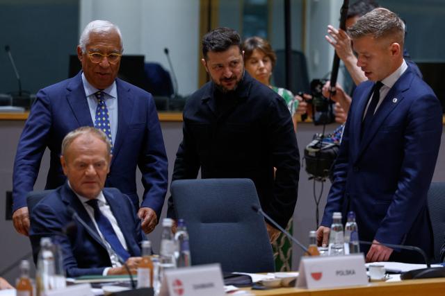 Ukraine's President Volodymyr Zelensky (C) speaks with Hungary's Prime Minister Peter Magyar (R) flanked by President of the European Council Antonio Costa (L) and Poland's Prime Minister Donald Tusk (bottom L) as they attend a round table meeting of EU leaders and Ukraine during the EU Summit at the EU headquarters in Brussels, on June 18, 2026. (Photo by Geert Vanden Wijngaert / POOL / AFP)