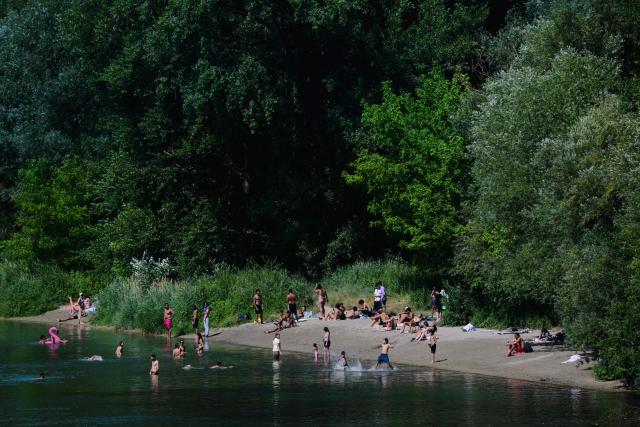 Bathers swim in the Rhone river during heatwave in center of Lyon, central France on June 18, 2026. A new heatwave swept across much of France, with temperatures forecast to approach 40C later in the week, dozens of trains cancelled and classes suspended. (Photo by OLIVIER CHASSIGNOLE / AFP)