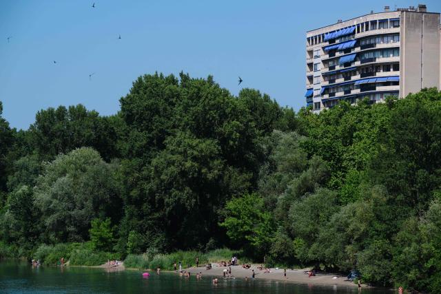Bathers swim in the Rhone river during heatwave in center of Lyon, central France on June 18, 2026. A new heatwave swept across much of France, with temperatures forecast to approach 40C later in the week, dozens of trains cancelled and classes suspended. (Photo by OLIVIER CHASSIGNOLE / AFP)