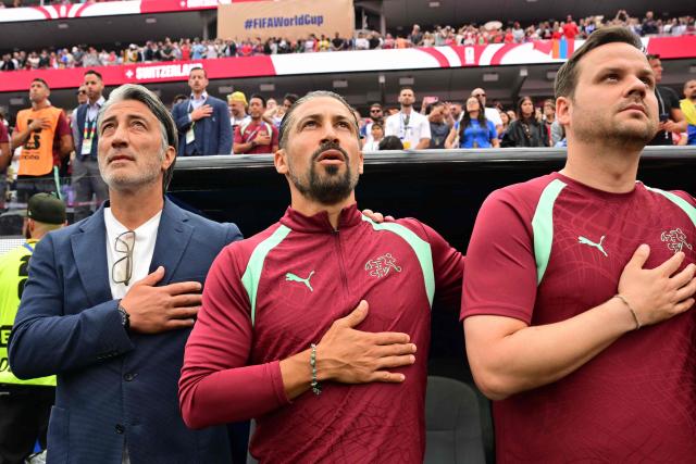 Switzerland's head coach Murat Yakin (L) and staff members sing the national anthem ahead of the 2026 World Cup Group B football match between Switzerland and Bosnia and Herzegovina at Los Angeles Stadium in Inglewood on June 18, 2026.  (Photo by Frederic J. Brown / AFP)