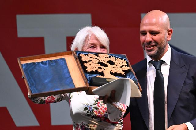 British actress Helen Mirren (C) displays the first major joint UK-Italy award presented to her, next to Italian actor Luca Medici alias "Checco Zalone", at the birthday celebrations of King Charles III, at Villa Wolkosky, Rome, on June 18, 2026. (Photo by Andreas SOLARO / AFP)