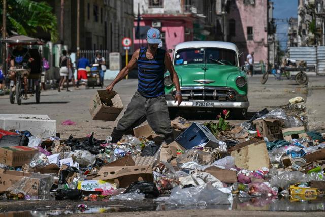 A man rummages through accumulated garbage on a street in Havana, on June 18, 2026. (Photo by YAMIL LAGE / AFP)