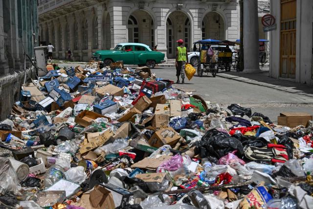 A man walks past garbage discarded on a street in Havana, on June 18, 2026. (Photo by YAMIL LAGE / AFP)