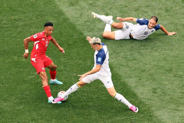 Switzerland's forward #11 Dan Ndoye and Bosnia-Herzegovina's defender #04 Tarik Muharemovic fight for the ball past Bosnia-Herzegovina's defender #18 Nikola Katic during the 2026 World Cup Group B football match between Switzerland and Bosnia and Herzegovina at Los Angeles Stadium in Inglewood on June 18, 2026.  (Photo by Etienne Laurent / AFP)