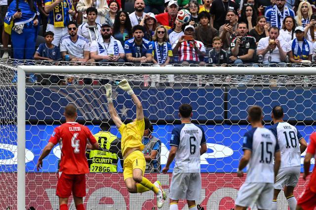Bosnia-Herzegovina's goalkeeper #01 Nikola Vasilj makes a save after a bicycle kick by Switzerland's forward #11 Dan Ndoye (unseen) during the 2026 World Cup Group B football match between Switzerland and Bosnia and Herzegovina at Los Angeles Stadium in Inglewood on June 18, 2026.  (Photo by Patrick T. Fallon / AFP)