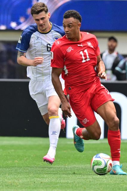 Switzerland's forward #11 Dan Ndoye runs with the ball past Bosnia-Herzegovina's midfielder #06 Benjamin Tahirovic during the 2026 World Cup Group B football match between Switzerland and Bosnia and Herzegovina at Los Angeles Stadium in Inglewood on June 18, 2026.  (Photo by Frederic J. Brown / AFP)
