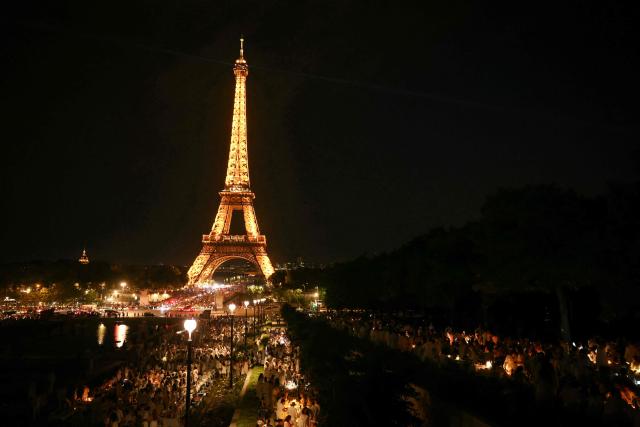Hundreds of diners gather at the Trocadero in front of the Eiffel Tower for a secret last minute mass diner in central Paris, on June 18, 2026. Diners dressed all in white set up their tables the evening of June 18, 2026, in front of the Eiffel Tower for a secret gathering, not announced until the last minute. Wearing smart formal attire with tables covered with white tablecloths brought by guests that left the same way they arrived, with no trace or waste. This concept was created in 1988 by François Pasquier and exported to a hundred cities worldwide. (Photo by Alain JOCARD / AFP)