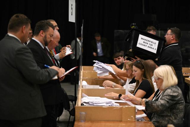 Election agents watch as votes are counted on ballot papers after polling for the Makerfield by-election closed, at the count centre venue, the Edge in Wigan, northwest England on June 18, 2026. (Photo by Oli SCARFF / AFP)