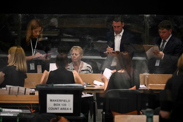 Election agents watch as votes are counted on ballot papers after polling for the Makerfield by-election closed, at the count centre venue, the Edge in Wigan, northwest England on June 18, 2026. (Photo by Oli SCARFF / AFP)
