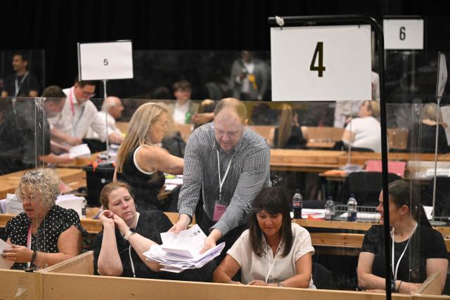 Ballot papers are distributed after polling for the Makerfield by-election closed, at the count centre venue, the Edge in Wigan, northwest England on June 18, 2026. (Photo by Oli SCARFF / AFP)