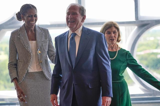 Former President George W. Bush laughs with former first lady Michelle Obama as former first lady Laura Bush watches, ahead of the dedication ceremony at the Obama Presidential Center on June 18, 2026, in Chicago. (Photo by Pablo Martinez Monsivais / POOL / AFP)