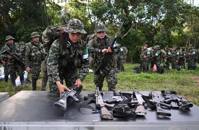 Members of the Coordinadora Nacional Ejercito Bolivariano (CNEB) guerrilla group lay down their weapons during a disarmament ceremony agreed with the Colombian government in the municipality of Valle del Guamuez, Putumayo department, Colombia on June 18, 2026. (Photo by Raul ARBOLEDA / AFP)