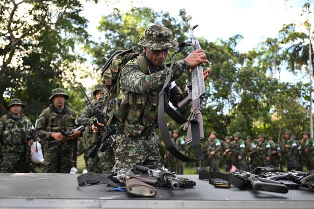 Members of the Coordinadora Nacional Ejercito Bolivariano (CNEB) guerrilla group lay down their weapons during a disarmament ceremony agreed with the Colombian government in the municipality of Valle del Guamuez, Putumayo department, Colombia on June 18, 2026. (Photo by Raul ARBOLEDA / AFP)