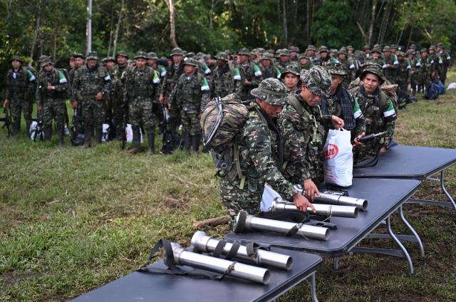 Members of the Coordinadora Nacional Ejercito Bolivariano (CNEB) guerrilla group lay down their weapons during a disarmament ceremony agreed with the Colombian government in the municipality of Valle del Guamuez, Putumayo department, Colombia on June 18, 2026. (Photo by Raul ARBOLEDA / AFP)