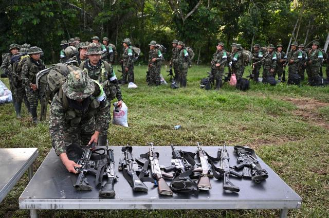 Members of the Coordinadora Nacional Ejercito Bolivariano (CNEB) guerrilla group lay down their weapons during a disarmament ceremony agreed with the Colombian government in the municipality of Valle del Guamuez, Putumayo department, Colombia on June 18, 2026. (Photo by Raul ARBOLEDA / AFP)