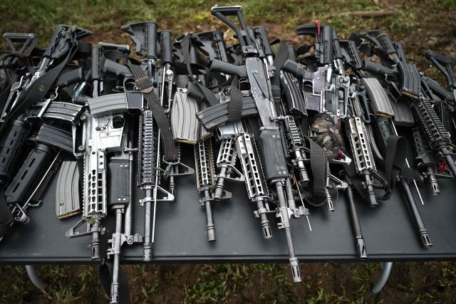 Weapons are displayed on a table during a disarmament process agreed with the Colombian government involving members of the Coordinadora Nacional Ejercito Bolivariano (CNEB) guerrilla group in the municipality of Valle del Guamuez, Putumayo department, Colombia, on June 18, 2026. (Photo by Raul ARBOLEDA / AFP)