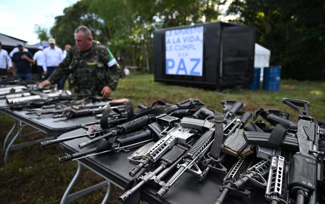 Members of the Coordinadora Nacional Ejercito Bolivariano (CNEB) guerrilla group take part in a disarmament ceremony agreed with the Colombian government in the municipality of Valle del Guamuez, Putumayo department, Colombia on June 18, 2026. (Photo by Raul ARBOLEDA / AFP)