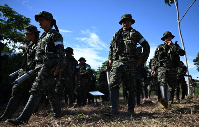 Members of the Coordinadora Nacional Ejercito Bolivariano (CNEB) guerrilla group take part in a disarmament ceremony agreed with the Colombian government in the municipality of Valle del Guamuez, Putumayo department, Colombia on June 18, 2026. (Photo by Raul ARBOLEDA / AFP)