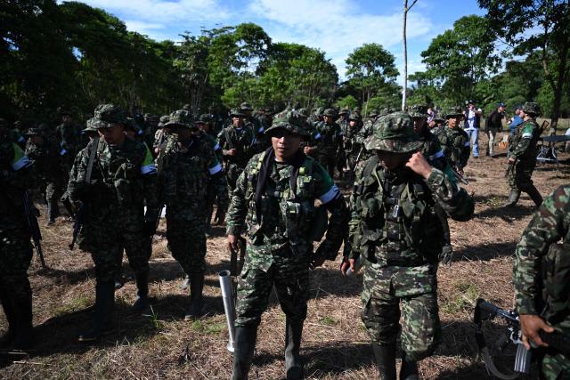 Members of the Coordinadora Nacional Ejercito Bolivariano (CNEB) guerrilla group take part in a disarmament ceremony agreed with the Colombian government in the municipality of Valle del Guamuez, Putumayo department, Colombia on June 18, 2026. (Photo by Raul ARBOLEDA / AFP)
