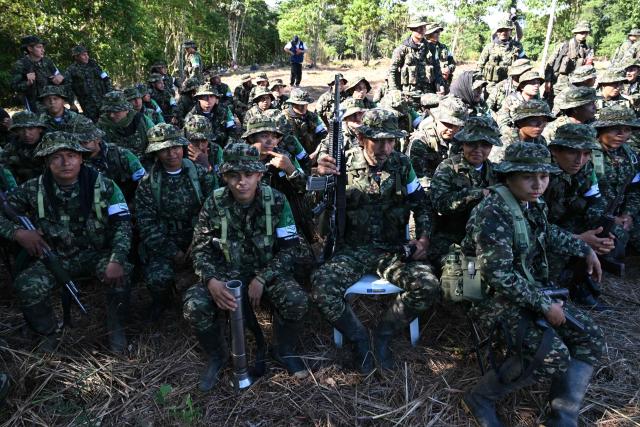 Members of the Coordinadora Nacional Ejercito Bolivariano (CNEB) guerrilla group take part in a disarmament ceremony agreed with the Colombian government in the municipality of Valle del Guamuez, Putumayo department, Colombia on June 18, 2026. (Photo by Raul ARBOLEDA / AFP)