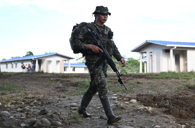A member of the Coordinadora Nacional Ejercito Bolivariano (CNEB) guerrilla group takes part in a disarmament ceremony agreed with the Colombian government in the municipality of Valle del Guamuez, Putumayo department, Colombia on June 18, 2026. (Photo by Raul ARBOLEDA / AFP)
