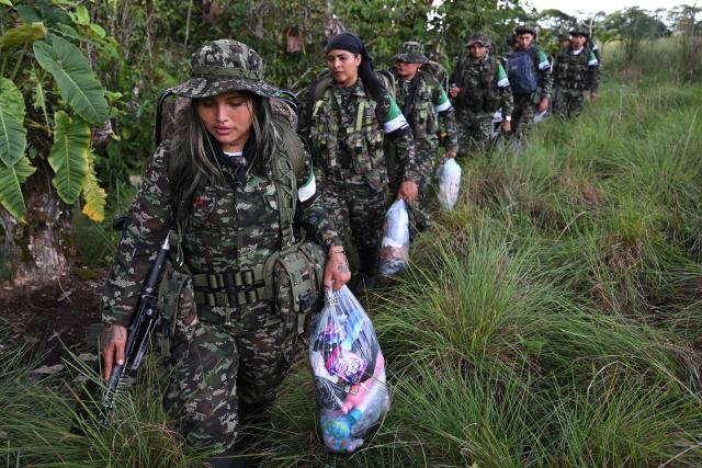 Members of the Coordinadora Nacional Ejercito Bolivariano (CNEB) guerrilla group take part in a disarmament ceremony agreed with the Colombian government in the municipality of Valle del Guamuez, Putumayo department, Colombia on June 18, 2026. (Photo by Raul ARBOLEDA / AFP)