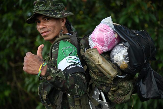A member of the Coordinadora Nacional Ejercito Bolivariano (CNEB) guerrilla group gives a thumbs up during a disarmament ceremony agreed with the Colombian government in the municipality of Valle del Guamuez, Putumayo department, Colombia on June 18, 2026. (Photo by Raul ARBOLEDA / AFP)