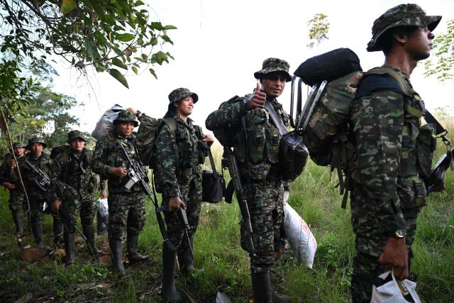 Members of the Coordinadora Nacional Ejercito Bolivariano (CNEB) guerrilla group take part in a disarmament ceremony agreed with the Colombian government in the municipality of Valle del Guamuez, Putumayo department, Colombia on June 18, 2026. (Photo by Raul ARBOLEDA / AFP)