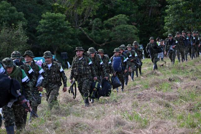 Members of the Coordinadora Nacional Ejercito Bolivariano (CNEB) guerrilla group take part in a disarmament ceremony agreed with the Colombian government in the municipality of Valle del Guamuez, Putumayo department, Colombia on June 18, 2026. Three days before a runoff vote set to determine the continuation of the country's first leftist government, this marks a first step for the rebels to settle in a special zone where they aim to consolidate agreements with the government. (Photo by Raul ARBOLEDA / AFP)
