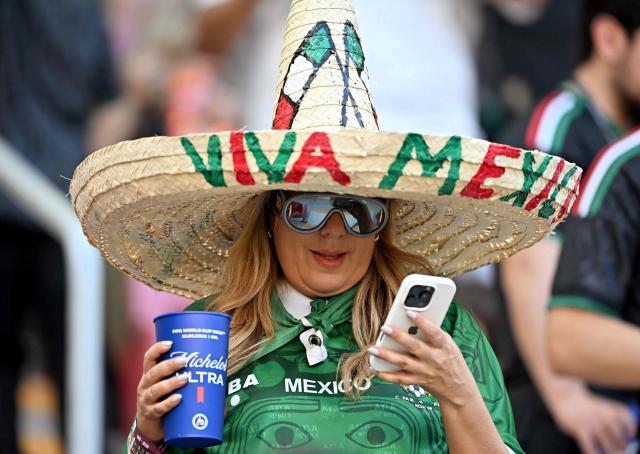 A Mexican fan looks at her phone ahead of the 2026 World Cup Group A football match between Mexico and South Korea at the Guadalajara Stadium in Zapopan on June 18, 2026.  (Photo by CARL DE SOUZA / AFP)