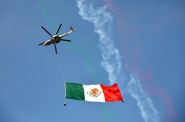 A helicopter carring a Mexican flag flies over the stadium ahead of the 2026 World Cup Group A football match between Mexico and South Korea at the Guadalajara Stadium in Zapopan on June 18, 2026.  (Photo by ULISES RUIZ / AFP)