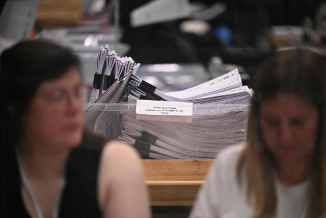 A container full of votes cast for Andy Burnham is seen as electoral staff count votes at the Edge in Wigan, northwest England on June 19, 2026. (Photo by Oli SCARFF / AFP)