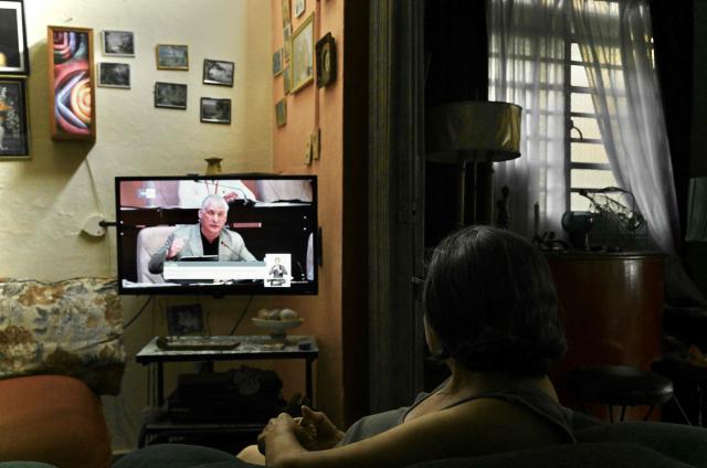 A woman watches a televised speech by Cuba's President Miguel Diaz-Canel at home in Havana, on June 18, 2026. (Photo by Yamil LAGE / AFP)