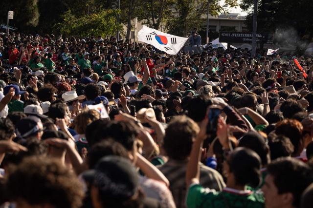 A South Korean flag is waved over a crowd of fans gathered to watch the 2026 World Cup match between South Korea and Mexico at Seoul International Park in the Koreatown neighborhood of Los Angeles on June 18, 2026. (Photo by ETIENNE LAURENT / AFP)