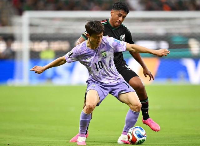 South Korea's midfielder #10 Lee Jae-sung and Mexico's defender #03 Cesar Montes fight for the ball during the 2026 World Cup Group A football match between Mexico and South Korea at the Guadalajara Stadium in Zapopan on June 18, 2026.  (Photo by CARL DE SOUZA / AFP)