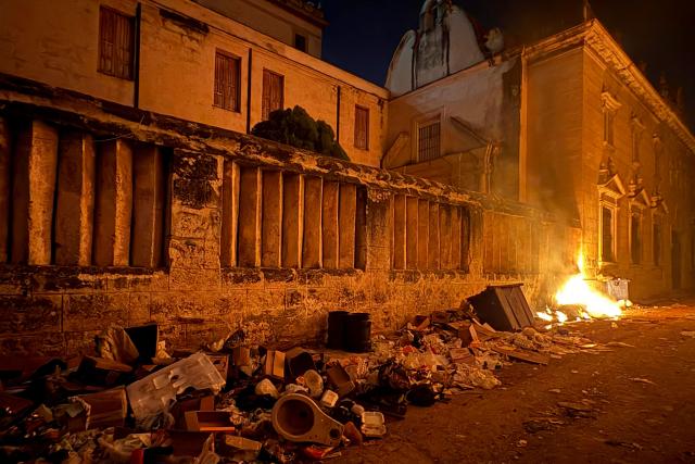 Piles of garbage burn along a street during a power outage in Havana on June 18, 2026. (Photo by Pablo PORCIUNCULA / AFP)