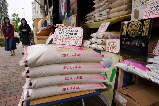 This picture taken on on April 24, 2026 shows bags of rice on display for sale outside a store in Tokyo. Rice prices in Japan finally fell in May for the first time in three and half years, officials said June 19, 2026, following sharp rises for the staple that put the government under huge pressure. (Photo by Kazuhiro NOGI / AFP)
