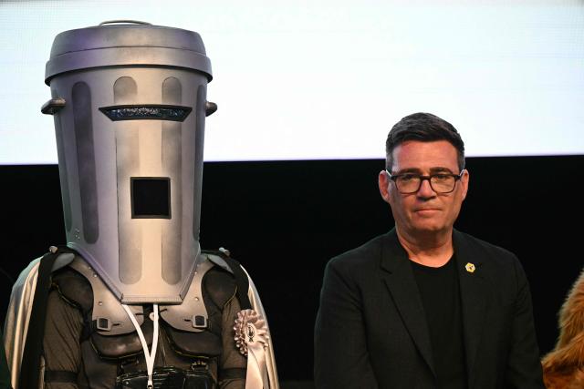 Count Binface stands next to Labour candidate Andy Burnham (R) after Burnham wins the election for MP of Makerfield, at the count centre venue, the Edge in Wigan, northwest England on June 18, 2026. (Photo by Oli SCARFF / AFP)