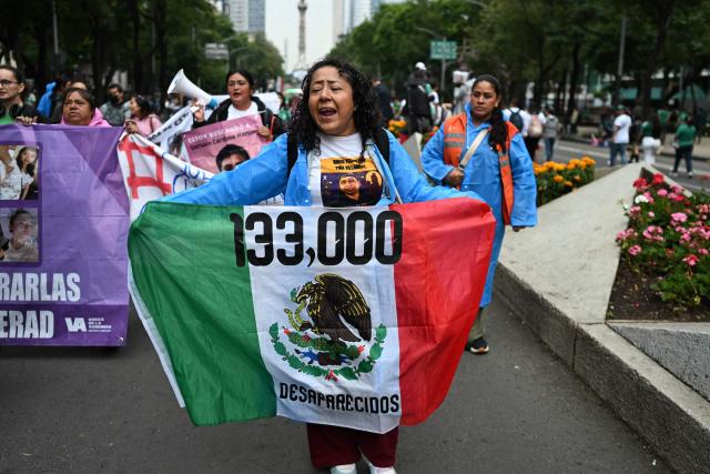 Mothers from groups searching for missing persons march near the Angel of Independence monument in Mexico City on June 18, 2026, as fans gather to watch the World Cup match between South Korea and Mexico. (Photo by Yuri CORTEZ / AFP)