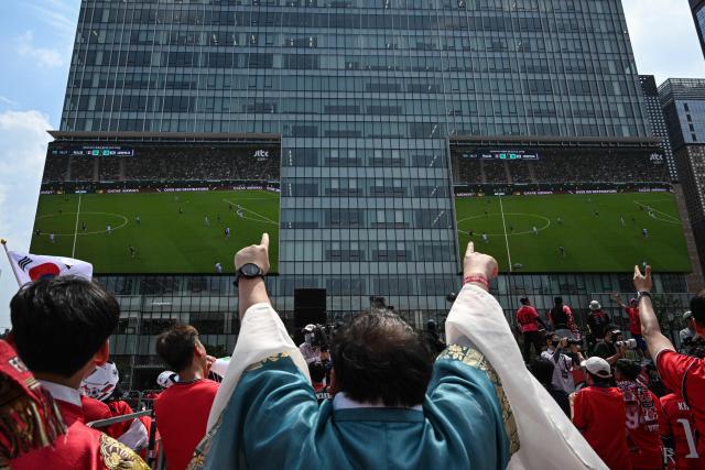 South Korean fans cheer as they watch the 2026 World Cup football match between South Korea and Mexico on big screens at Gwanghwamun Square in Seoul on June 19, 2026. (Photo by Jade GAO / AFP)