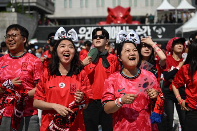 South Korean fans cheer as they watch the 2026 World Cup football match between South Korea and Mexico on big screens at Gwanghwamun Square in Seoul on June 19, 2026. (Photo by Jade GAO / AFP)