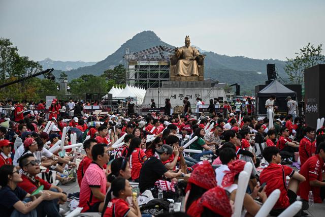 South Korean fans watch the 2026 World Cup football match between South Korea and Mexico on big screens at Gwanghwamun Square in Seoul on June 19, 2026. (Photo by Jade GAO / AFP)
