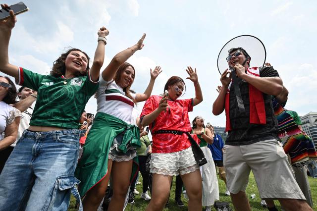 Mexican fans celebrate after their team win the 2026 World Cup football match against South Korea at Gwanghwamun Square in Seoul on June 19, 2026. (Photo by Jade GAO / AFP)