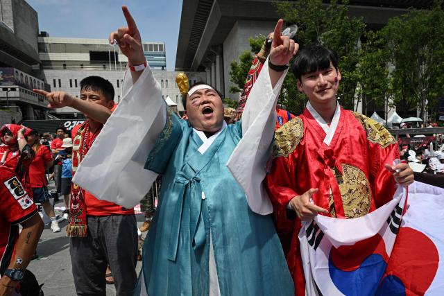 South Korean fans cheer as they watch the 2026 World Cup football match between South Korea and Mexico on big screens at Gwanghwamun Square in Seoul on June 19, 2026. (Photo by Jade GAO / AFP)