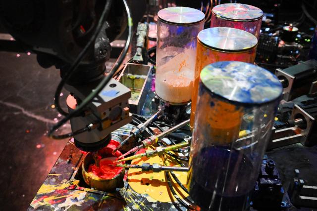 The Qualia Process robotic arm creates an oil painting from a visitors journey data after viewing immersive visualizations from the inaugural exhibition Machine Dreams: Rainforest are projected at DATALAND, the Museum of AI Arts, in Los Angeles, California on June 9, 2026. The squawks of macaws, the smell of wet earth after rain, and the swirl of colours will transport visitors to a Los Angeles museum to the heart of the Amazon rainforest -- or rather, an AI version of it. Data collected from those visitors  their movements, their heartbeats, and even the temperature of their skin -- will feed the computer that is creating the immersive display, using a network of sensors, including those on the wrists of ticket-holders. (Photo by Patrick T. Fallon / AFP)
