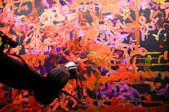 The Qualia Process robotic arm creates an oil painting from a visitors journey data after viewing immersive visualizations from the inaugural exhibition Machine Dreams: Rainforest are projected at DATALAND, the Museum of AI Arts, in Los Angeles, California on June 9, 2026. The squawks of macaws, the smell of wet earth after rain, and the swirl of colours will transport visitors to a Los Angeles museum to the heart of the Amazon rainforest -- or rather, an AI version of it. Data collected from those visitors  their movements, their heartbeats, and even the temperature of their skin -- will feed the computer that is creating the immersive display, using a network of sensors, including those on the wrists of ticket-holders. (Photo by Patrick T. Fallon / AFP)
