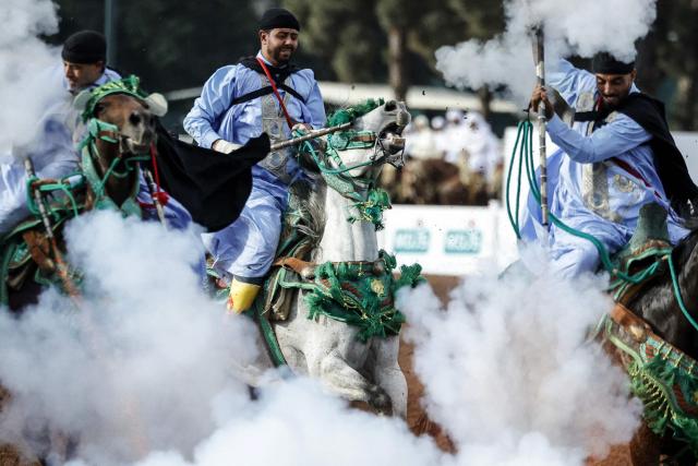 Moroccan horsemen ride in traditional attire and fire rifles during a Tbourida, or Fantasia, equestrian performance at the Hassan II Tbourida Trophy in Rabat on June 18, 2026. The traditional equestrian discipline, also known as Fantasia, features cavalry charges followed by synchronized rifle volleys, preserving a Moroccan cultural heritage recognized by UNESCO as an Intangible Cultural Heritage of Humanity. (Photo by Abdel Majid BZIOUAT / AFP)